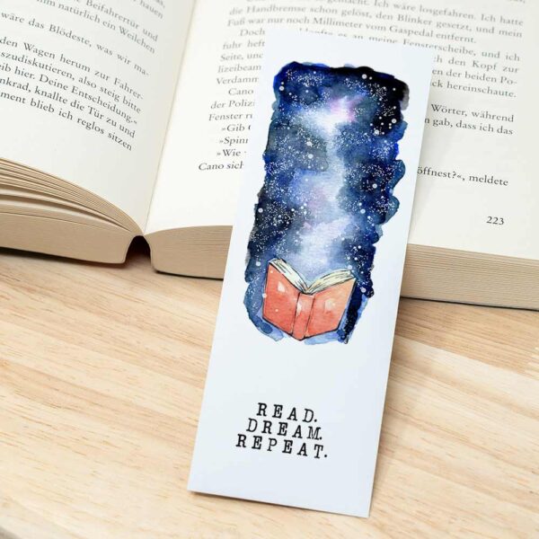 Lesezeichen "read.dream.repeat" neben Buch
