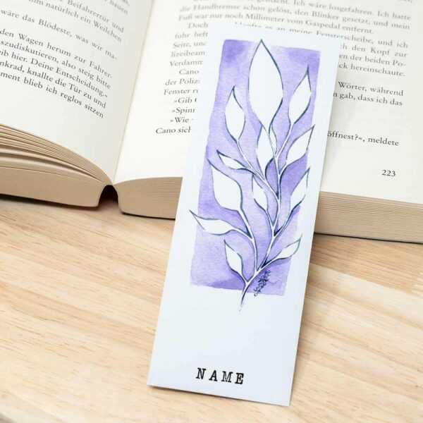 Lesezeichen mit Blumen neben Buch