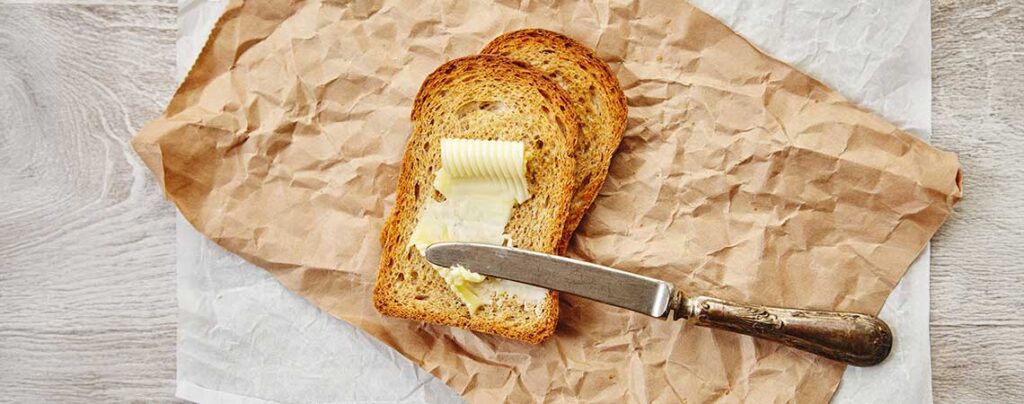 Frühstücksbrot streicht Butter auf Brot