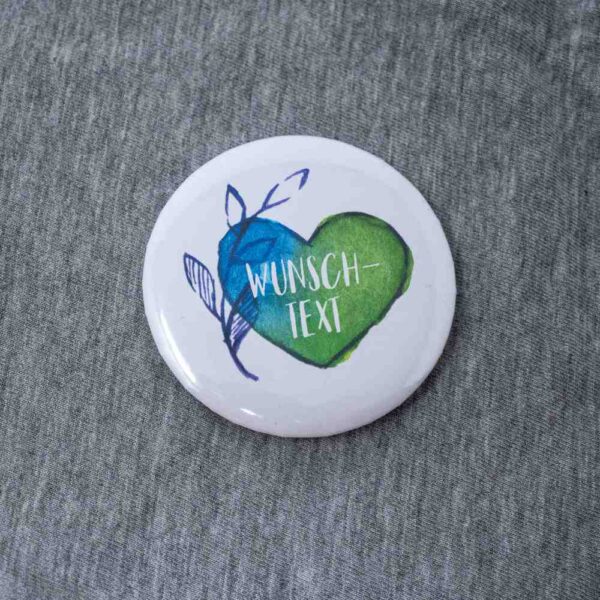 58 mm Button mit blaugrünem Herz und Wunschtext auf Textil
