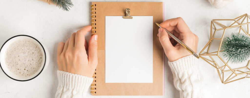 Frau sitzt am Tisch vor leerem Blatt