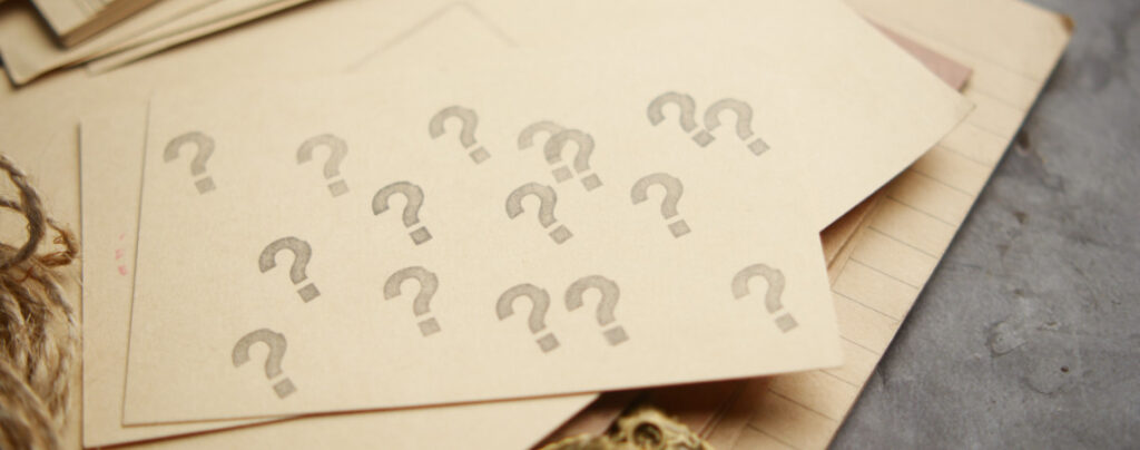 Papier mit vielen Fragezeichen drauf