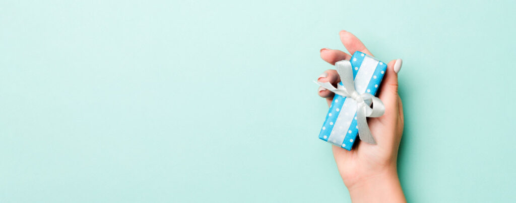 Hand hält kleines Geschenk in Händen