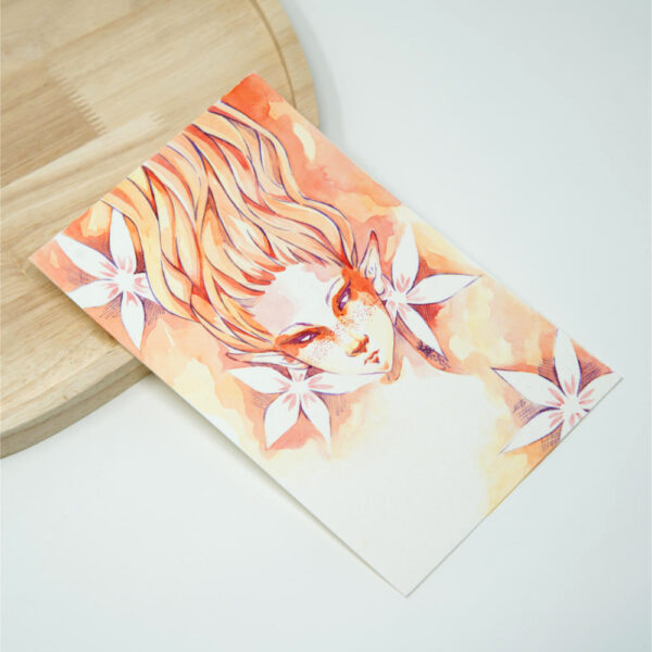 Handgemalte Manga Originalzeichnung einer Feuer-Elfe mit flammendem orangerotem Haar, Sommersprossen und lila Augen, umgeben von weißen Blüten vor warmem Orange-Gold Aquarellhintergrund.