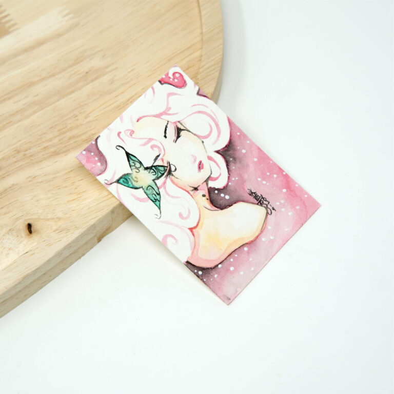 Handgezeichnete ACEO Karte mit weißhaarigem Manga-Mädchen im Profil, schwarzen Tränen auf der Wange und grünem Schmetterling vor rosa Aquarellhintergrund mit weißen Lichtpunkten.