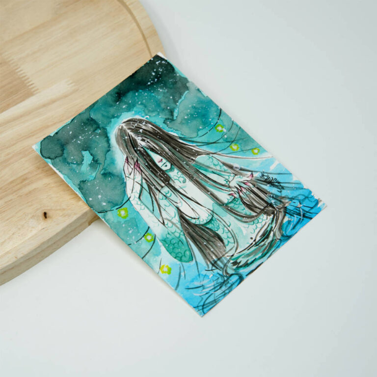 Handgezeichnete Manga Originalzeichnung einer Meerjungfrau mit langem dunklen Haar vor türkis-blauem Aquarellhintergrund mit grünen Blüten und schimmernden Fischschuppen.