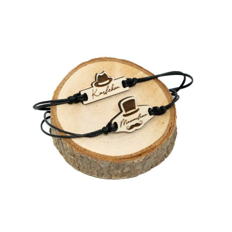 Zwei verstellbare schwarze Kordel-Armbänder auf Holzscheibe, oben Gentleman-Hut-Armband mit Namen Karlchen, unten Mister-Moustache-Armband mit Namen Maximilian, beide aus naturbelassenem Holz mit Lasergravur.